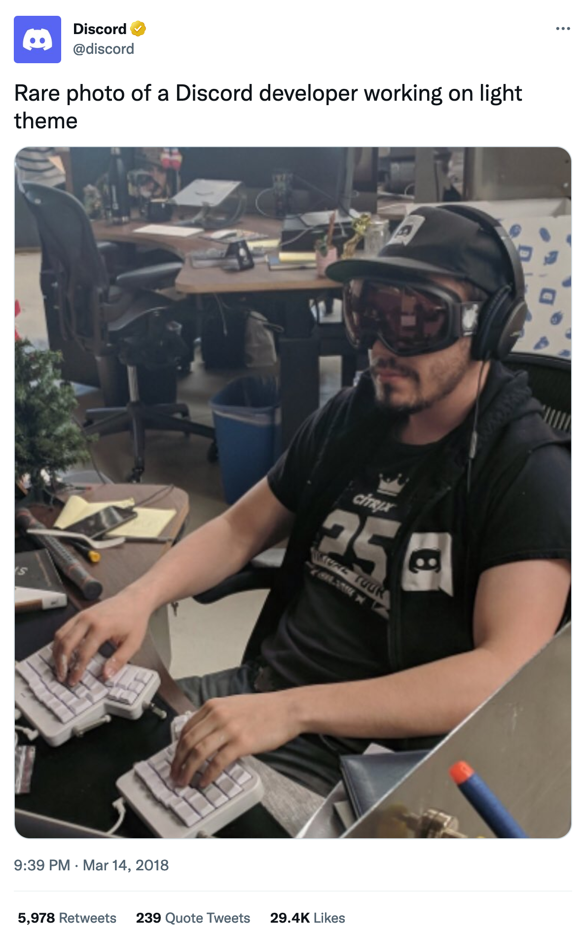 A screenshot of a tweet from @Discord showing a person with ski goggles with the caption 'Rare photo of a Discord developer working on light theme'